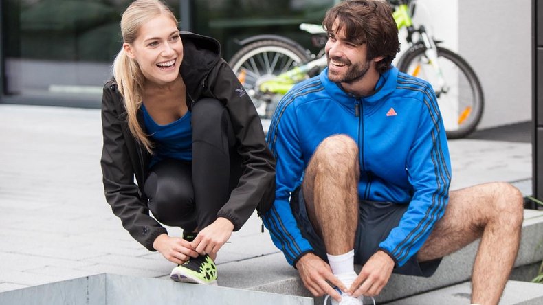 Mann und Frau binden ihre Laufschuhe