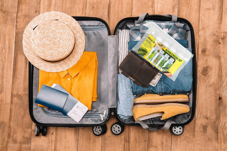 Aufgeklappter gepackter Koffer mit Alma's Reise Set
