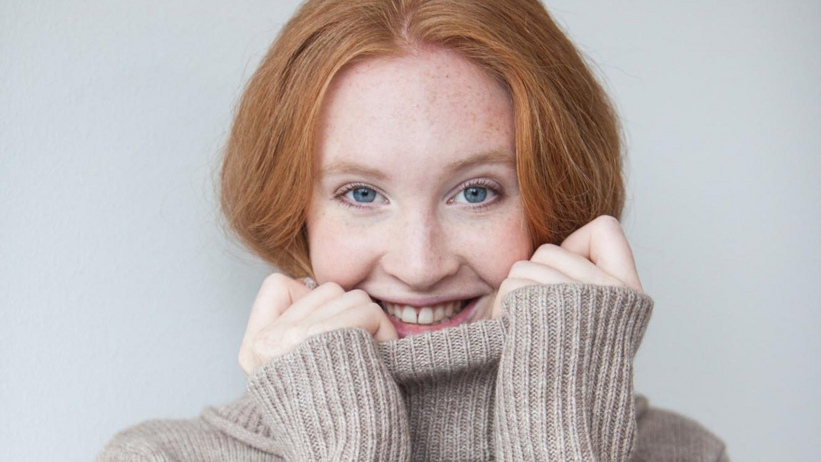 Junge Frau mit roten Haaren im Rollkragenpullover